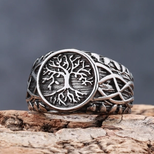 Macro shot of Viking tree of life relief on vintage stainless steel ring over wood