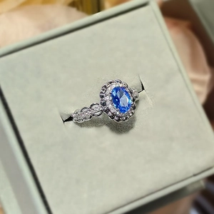 Elegant oval blue sapphire ring with sparkling white diamonds in a luxury jewelry box