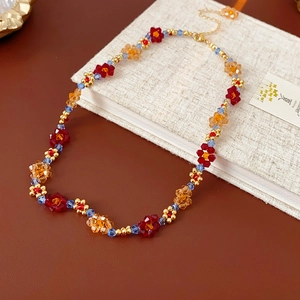 Détail du collier de fleurs perlées colorées avec fermoir mousqueton et accents dorés