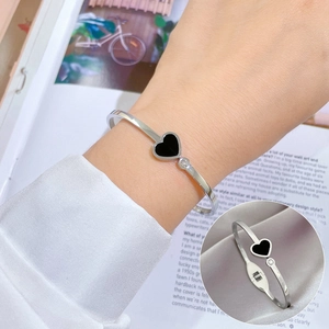 Silver stainless steel heart bangle with black enamel and single diamond accent