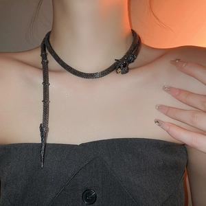 Detail of snake-shaped choker with woven mesh texture and gemstone-encrusted head