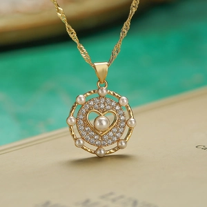 Macro shot of gold necklace pendant with zircons and pearls on book background