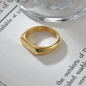 Minimalist 4mm wide gold titanium steel signet ring shown in a stylized product layout