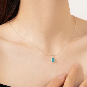 Close-up of a blue teardrop zircon pendant on an 18K gold-plated S925 silver chain