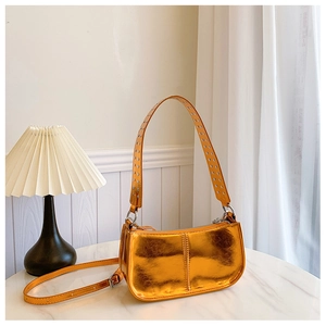 Détail du sac bandoulière orange doré métallisé avec rivets argentés sur la sangle