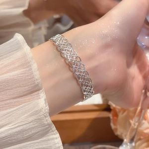 Gros plan détaillé du bracelet manchette argenté ajouré avec texture dentelle fine