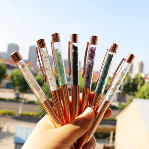 Rose gold crystal ballpoint pens filled with colorful natural gemstone chips in hand