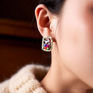 Close-up of vintage square stud earring with colored beads and zircon on model's ear