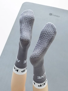 Close-up of grey yoga socks with anti-slip silicone grips and white calf-high cuffs