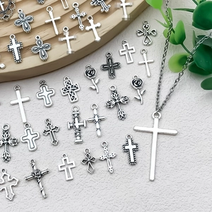 Vista dettagliata di vari ciondoli a croce in argento vintage per gioielli e collane DIY