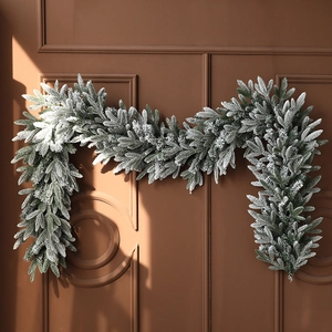 Realistic PE mixed green Christmas garland with snow effect hanging on a classic wooden door