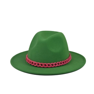 Detail of green felt fedora hat featuring a chunky pink decorative chain accessory