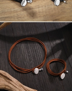 Close-up of black and brown leather cord necklaces with silver charms on wooden backgrounds
