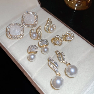 Detailed set of six gold-tone earrings with pearls and crystals in a velvet jewelry box