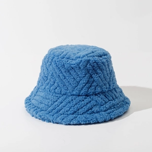Close-up of bright blue lamb wool bucket hat with soft sherpa texture and geometric patterns
