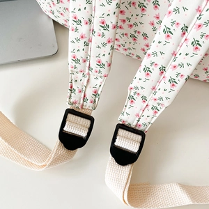 Detail of floral backpack showing adjustable buckle and durable woven shoulder strap