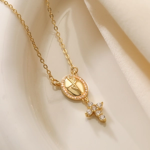 18K gold plated copper necklace with zircon cross pendant on a white ceramic plate