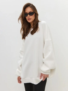 Detail showing soft cotton fabric texture and stitching of white oversized sweatshirt