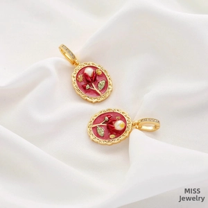 Detail of vintage gold-framed red enamel oval pendant with pearl and floral motif