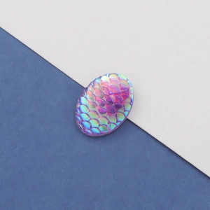 Macro detail of 13x18mm oval mermaid scale resin cabochon with purple AB iridescent finish
