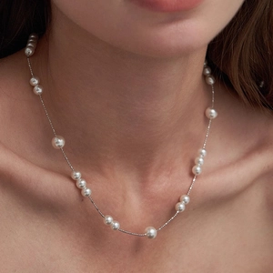 French vintage pearl necklace with silver chain shown on neck in a minimalist style