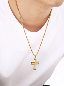 Gros plan du pendentif croix en acier titane plaqué or 18 carats sur t-shirt blanc