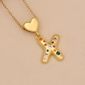 Macro shot of gold heart pendant with letter X featuring multi-color round zircon stones