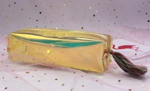 Close-up of holographic gold pencil case with colorful tassel and smooth metal zipper