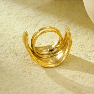 Macro view of a gold geometric textured ring and scarf buckle on a textured background
