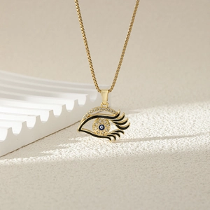 Golden heart evil eye pendant necklace with blue enamel and sparkling crystal accents