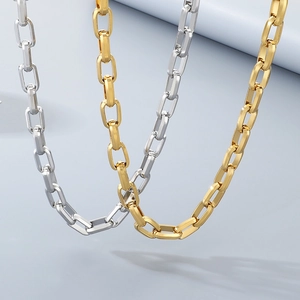 Detailed view of interconnected rectangular link chains in gold and silver steel finish