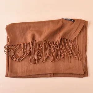 Detail view of coffee brown cashmere scarf with long fringe and decorative brand label