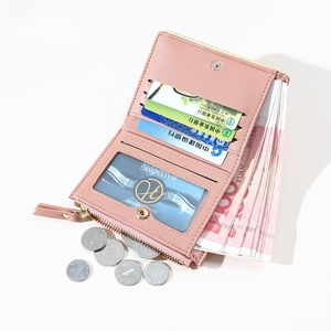 Pink bi-fold leather wallet detail showing card slots, bill layer and zipper pocket