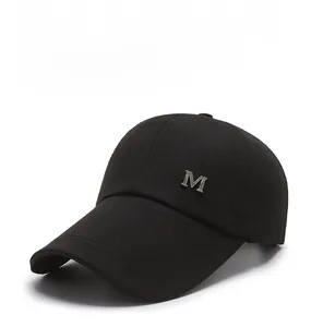 Detailed side view of black cotton baseball cap with silver metal M logo emblem