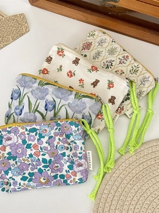 Set of four floral canvas storage pouches with vibrant green woven rope handles