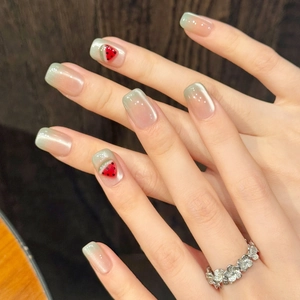 Detail of mint green cat-eye nails with watermelon art and silver floral ring