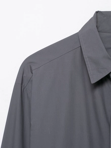 Close-up of neck and shoulder detailing on a dark grey poplin shirt with sharp stitching