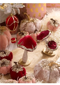 Close-up of velvet pumpkins and mushrooms with gold glitter and sequins for Christmas