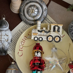 Close-up of astronaut and Christmas ornaments set on cream porcelain plate