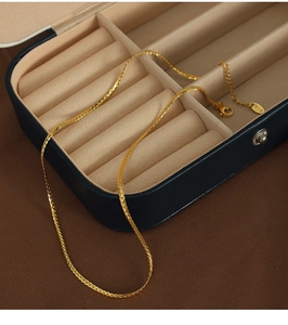 Close-up of gold-plated double-layer necklace with cotton beads in a blue jewelry box