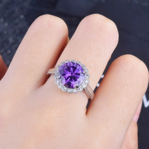 Macro shot of 5 carat purple gemstone ring with diamond halo on silver band