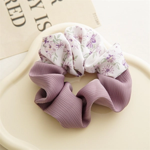 Detail of floral and purple pleated fabric textures on a large aesthetic hair scrunchie