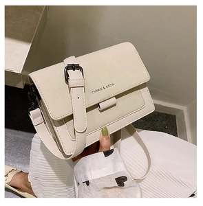 Detail of cream-colored flap crossbody bag with mixed suede texture and metal buckle strap