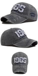 Detailed embroidery of 1985 on washed grey cotton baseball cap with distressed texture