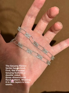 Detailed macro view of vintage silver hollow cosmos flower links and dual-layered chain