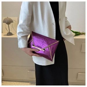 Fashionable purple crocodile pattern envelope clutch bag held by a model in casual attire