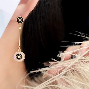 Dettaglio di orecchini vintage placcati oro con motivo a stella e intarsio su modella