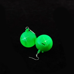 Detailed view of neon green disco ball earrings with reflective surface on black background