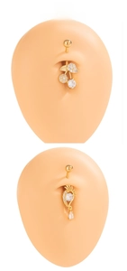 Detail of gold navel rings with cherry design and crystals on a silicone belly model