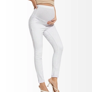 Detailed close-up of high waist support and texture on white maternity skinny jeans